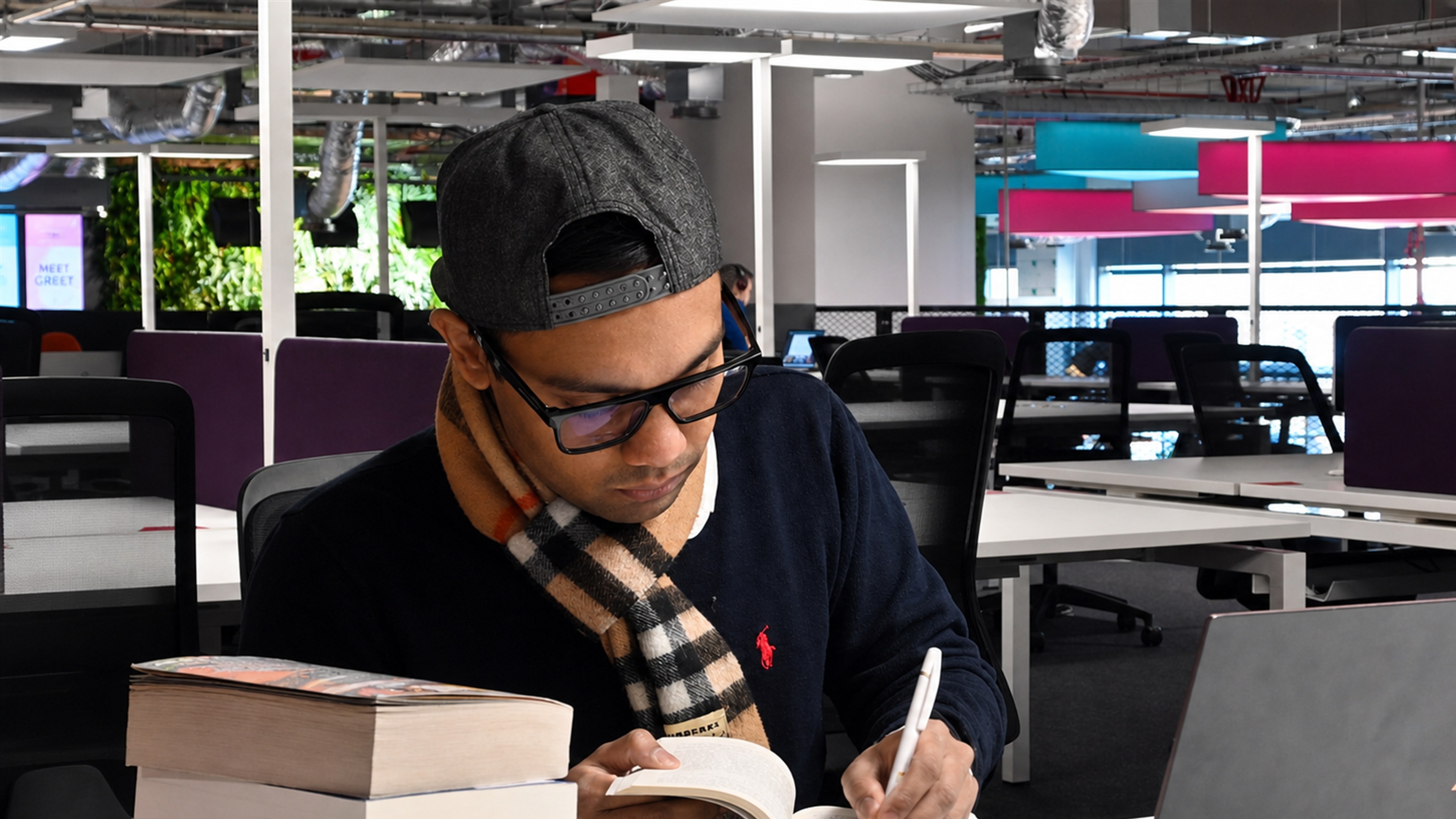 Farabi writing in a notebook at Plexal